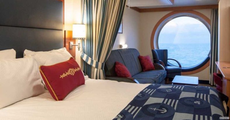 A large porthole window looking onto the ocean from a Disney cruise stateroom