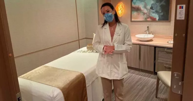 A spa technician stands near a massage table at Senses spa onboard a Disney cruise ship