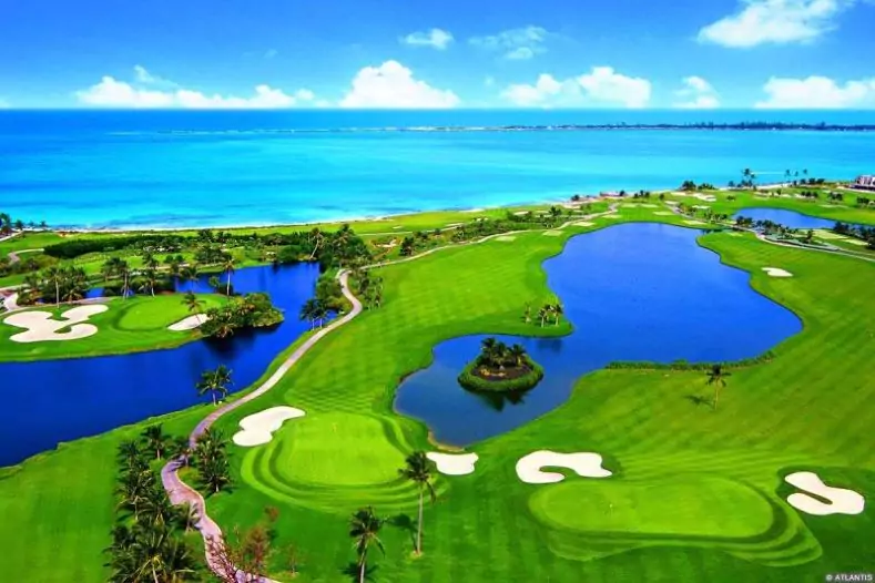 Atlantis - Ocean Club Golf Course - a lush green golf course beside crystal blue waters