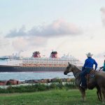 Disney Cruises From Galveston - two persons sitting on horseback watch as the Disney Magic cruise ship sails by