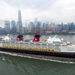 A Disney Cruise Ship sails in front of the New York City skyline