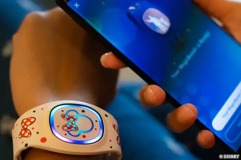 A Minnie Mouse decorated MagicBand and a mobile phone