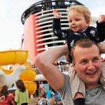 A young child is held on an adult's shoulders while onboard a Disney Cruise Ship | Image © Disney