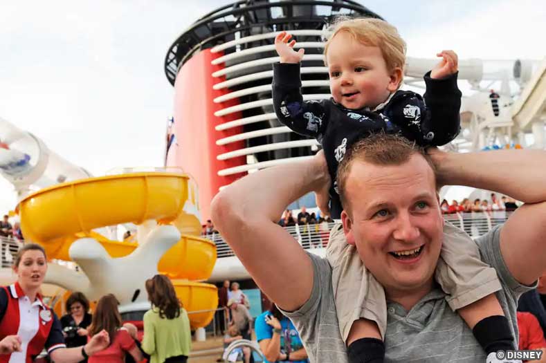 A young child is held on an adult's shoulders while onboard a Disney Cruise Ship | Image © Disney