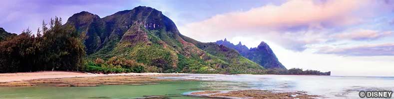 A mountain abuts the water against a pink-blue sky on Nawiliwili, Hawaii