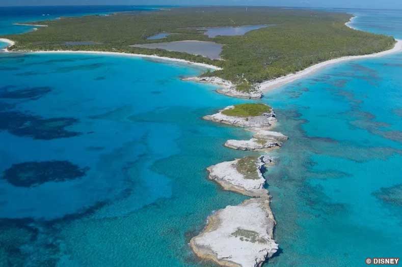 Aerial View of Lighthouse Point - the Disney Cruise private port on Eleuthera, Bahamas - showing crystal blue-green waters and a lush green island with white rocky outcroppings | Image © Disney
