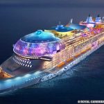 How to Charter A Cruise Ship (2026 Update) A nighttime view of Royal Caribbean's Icon of the Seas cruise ship, with multicolored lights glowing throughout the ship