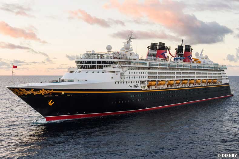 The Disney Magic cruise ship sails along the open ocean with a vivid sky as a backdrop | Image © Disney