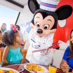 Disney Dining Plan: Complete Guide for 2026 & 2027 DIsney Dining Plan -- Mickey Mouse, in chef's outfit, visits the table of a family enjoying breakfast | Image © Disney
