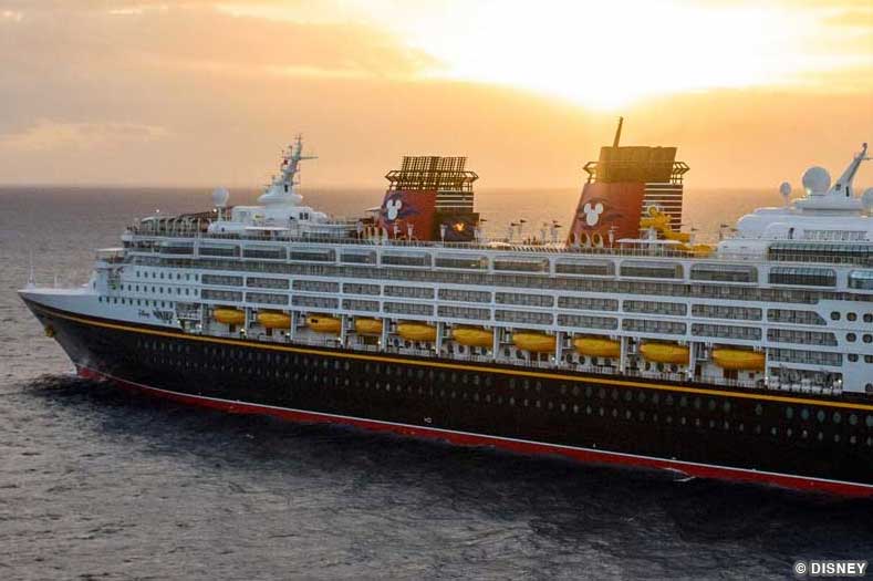 The Disney Wonder sails past a sunset