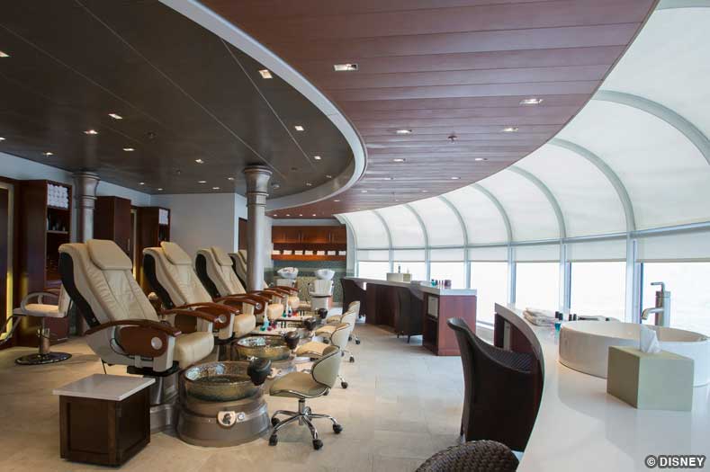 Pedicure chairs face large oceanview windows at Senses Spa on Disney Magic.