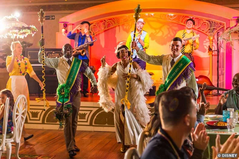 Performers in brightly-colored Mardi Gras costumes at Tiana's Place on the Disney Wonder cruise ship