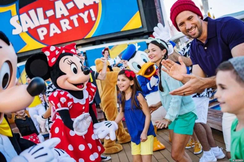 Disney Characters and Cruise Passengers dance together on the deck of a Disney Cruise Ship