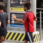 Universal Orlando Height Requirement Calculator Children walk past a height requirement measuring pylon at Universal Orlando