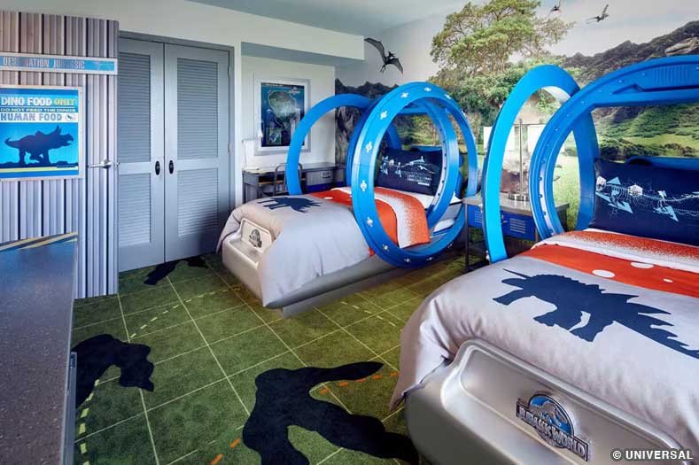 A Jurassic World Kids suite with beds, carpet, and wall art themed to the Jurassic Park/World franchise