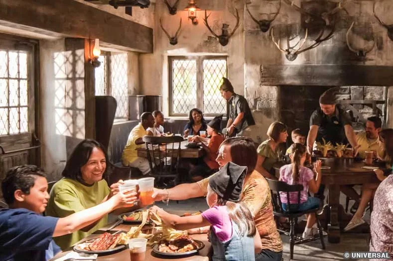Guests eating inside of Three Broomsticks, with dark pub décor