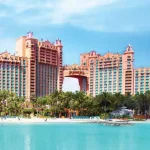 Exterior of the Atlantis Bahamas resort main towers with vibrant blue water in the foreground | Image © Atlantis