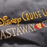 An embroidered Disney Cruise Line Castaway Club logo on a backpack
