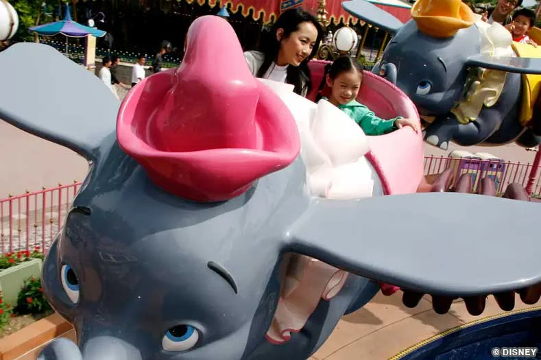 An adult and child ride the Dumbo the Flying Elephant attraction | Image © Disney