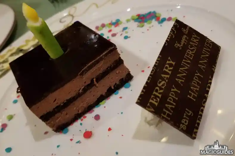 A small piece of chocolate cake/mousse, with the words "happy anniversary," at a Disney restaurant