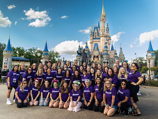 A group of Vacationeer travel agents in front of Cinderella Castle