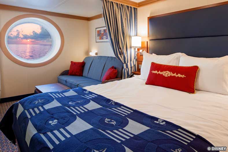An oceanview stateroom with bed and couch on the Disney Dream and Disney Fantasy