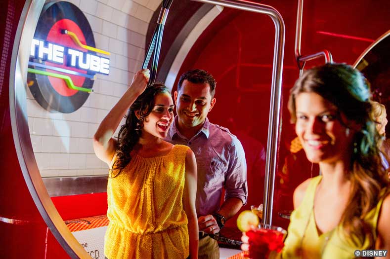 A Guest holds a strap, subway-style, in a lounge themed to the London Underground