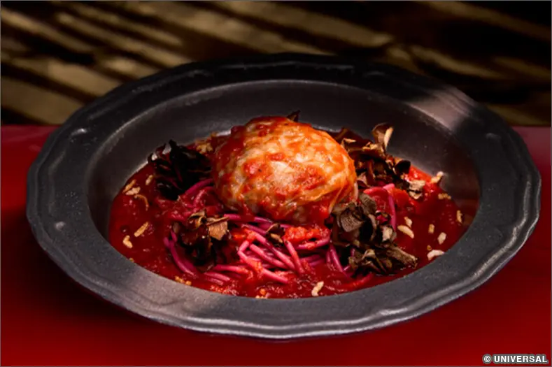 A Vegan Stuffed Cabbage dish with a red sauce, served in a black bowl