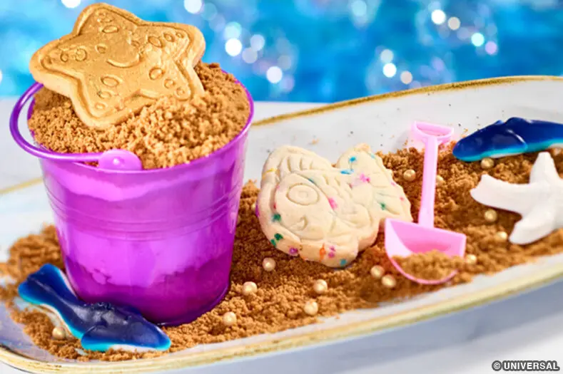 marine life shaped cookies and gummy sharks, served on a tray with a miniature pail and shovel, at Atlantic in Universal's Epic Universe